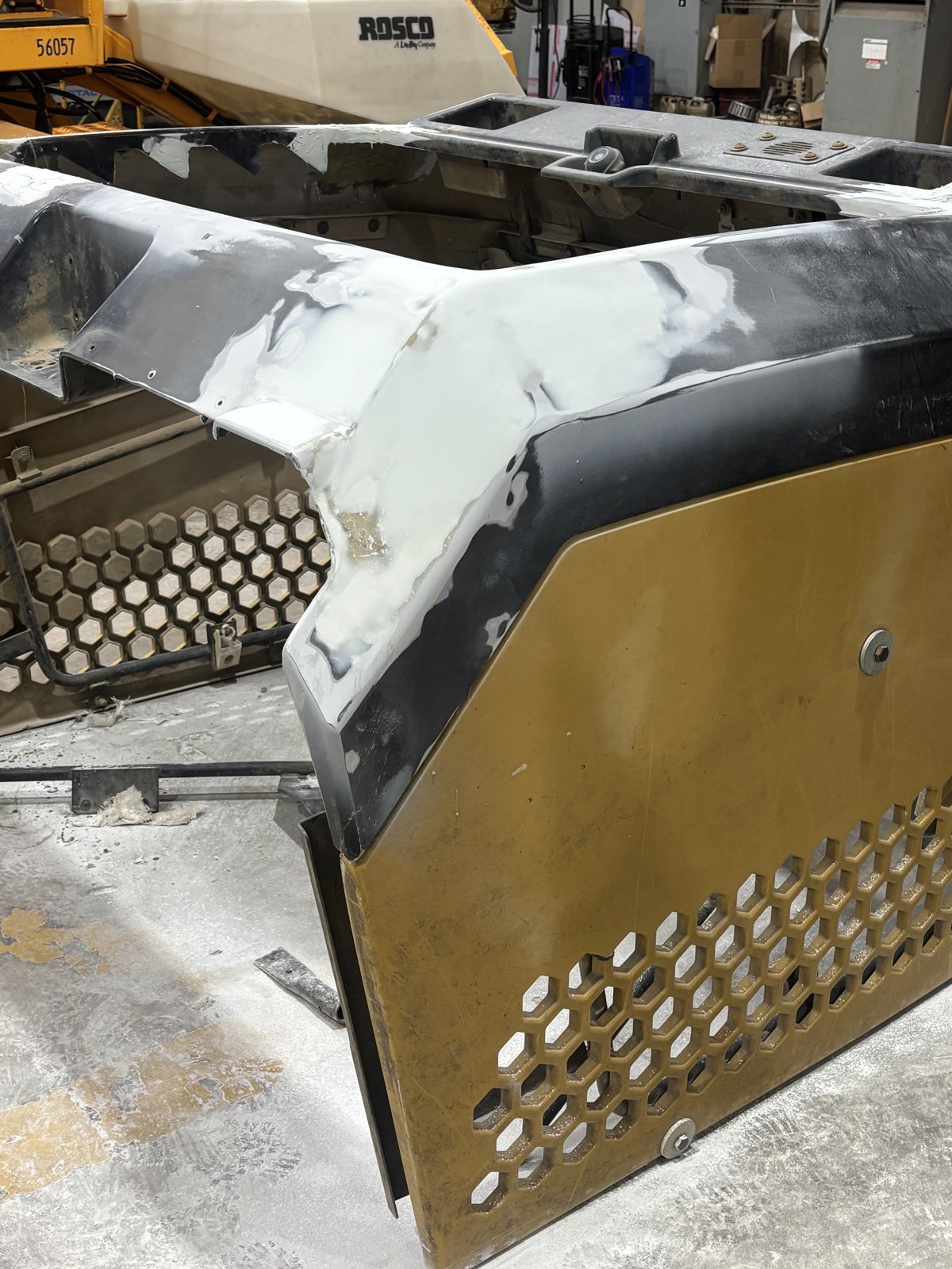 Equipment hood panel in primer with a perforated grille, on a stand