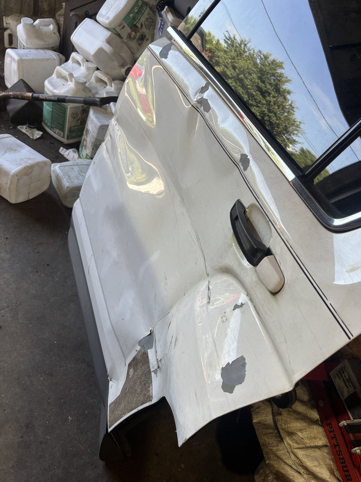 A white pickup door and bedside in primer, outdoors