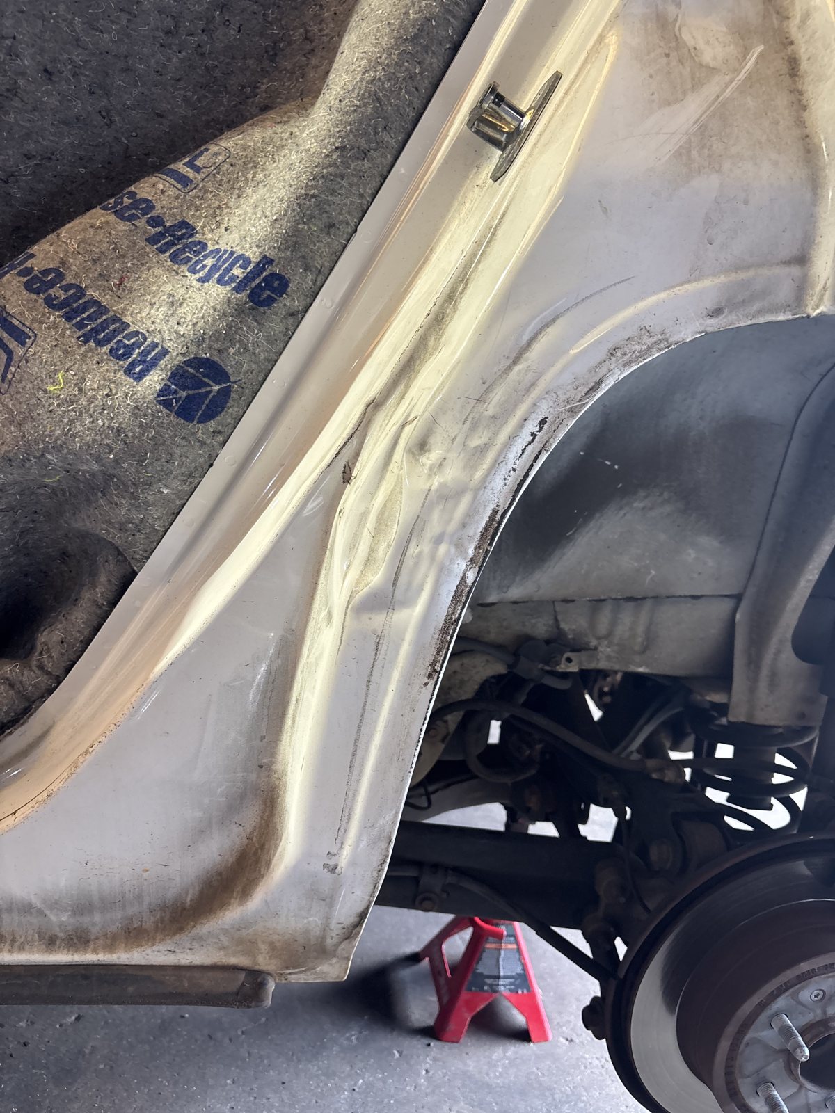 Pickup rear quarter panel with filler feathered, brake rotor visible